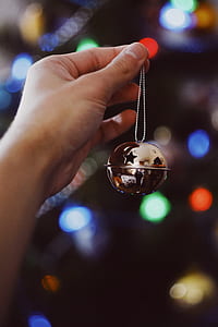 person holding gold-colored bell thumbnail