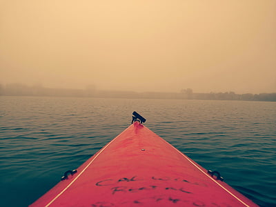 red surfboard on calm sea during foggy weather thumbnail