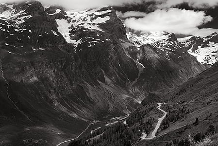 Greyscale Photo of Mountains Surrounded by Clouds thumbnail