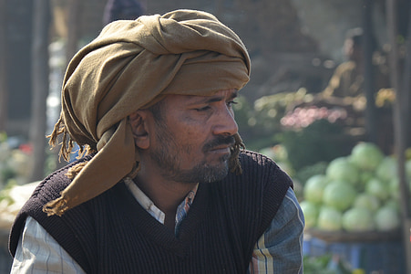 man in brown turban headdress and black vest thumbnail