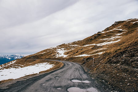 cleared road near mountain during daytime thumbnail