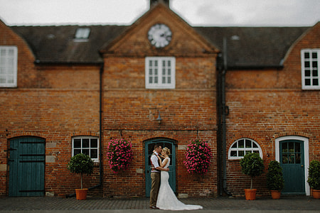 couple embracing each other in front of house thumbnail