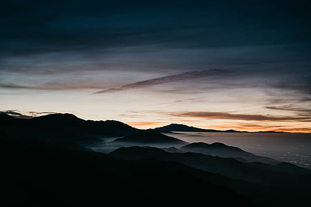 silhouette of mountains under cloudy sky thumbnail