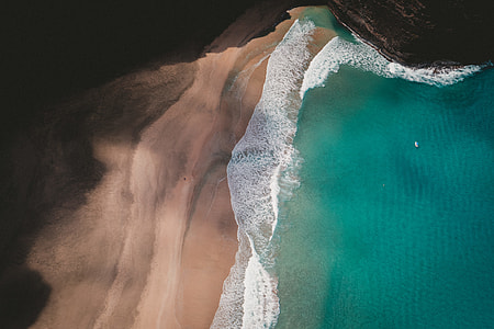aerial photography of seashore and brown mountain cliff thumbnail