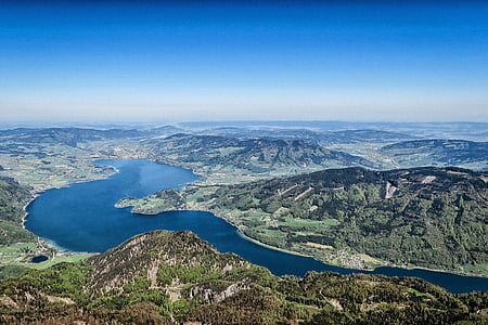 trees covered mountain near body of water thumbnail