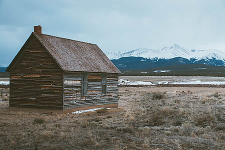 brown wooden house near mountain thumbnail