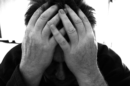 gray scale of man holding his forehead thumbnail
