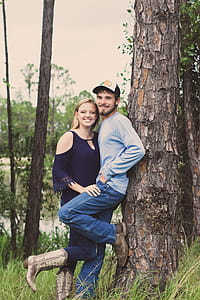 Couple Taking Photo Beside A Tree thumbnail