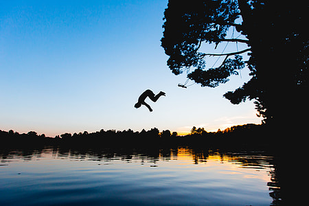 silhouette of man diving on body of water thumbnail