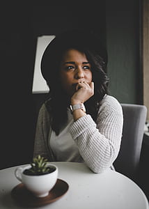 woman sitting on gray chair wearing gray sweater looking sideways thumbnail