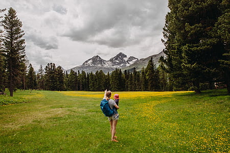 person carrying a todller pointing to the mountain thumbnail