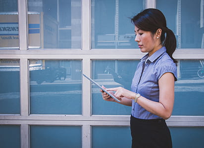 woman wearing blue shirt holding an Android tablet computer thumbnail