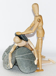 two brown wooden mannequins on gray stone thumbnail