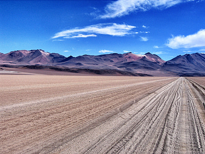 brown field near mountain range thumbnail