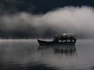 people riding on water boat on calm body of water during nighttime thumbnail