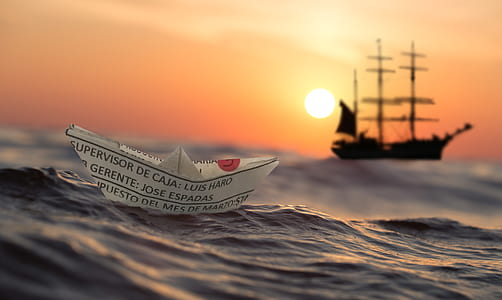 paper boat on body of water during sunset thumbnail