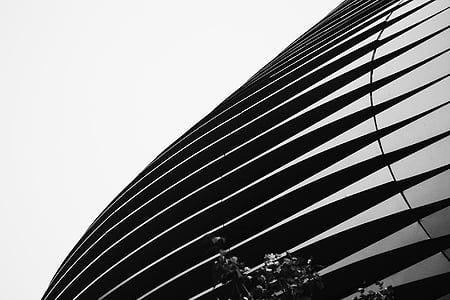 grayscale photo of building under gray sky thumbnail