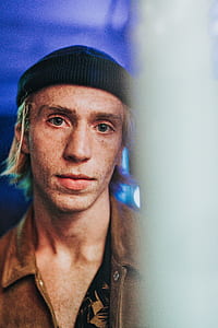 man wearing black knit cap and brown tops thumbnail