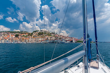 white sailboat heading on city buildings during daytime thumbnail