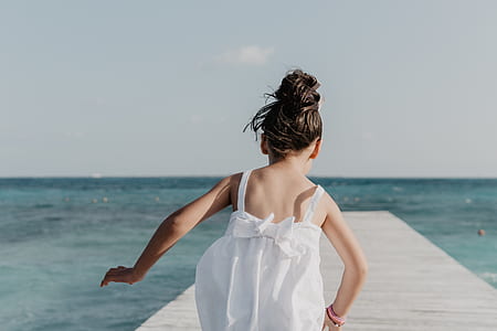 girl wearing dress about to walk on dock bay thumbnail