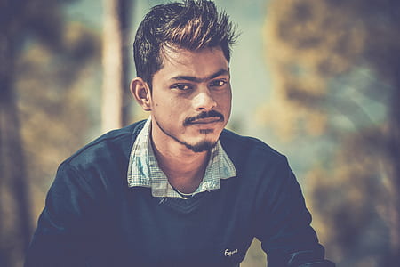 Shallow Focus Photography of Man Wearing Blue Sweater thumbnail