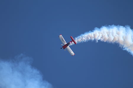red and white plane doing air smoke show thumbnail
