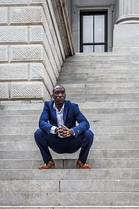 man in blue suit jacket and pants sitting on gray stair thumbnail