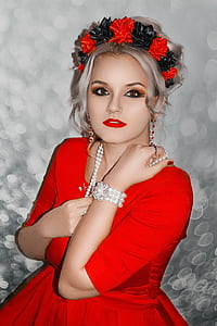 closeup photo of model woman wearing red dress and pearl necklace taking photo inside room thumbnail