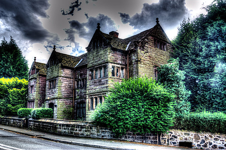 brown and gray building beside trees under black clouds during daytime thumbnail