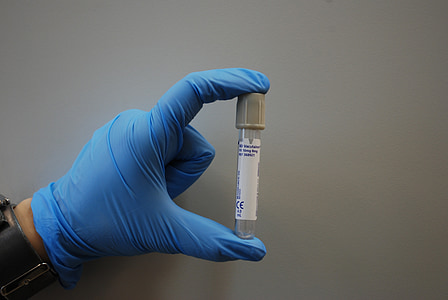 person holding white and gray tube bottle thumbnail