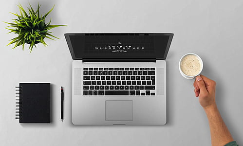 turned on MacBook Pro beside coffee mug thumbnail