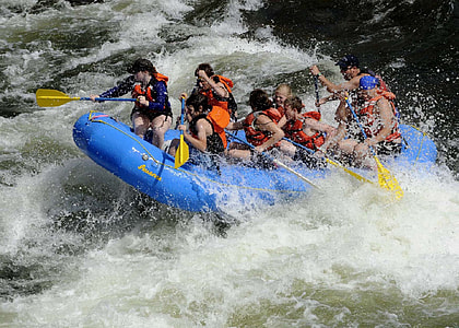 people on blue inflatable raft paddling on river tide thumbnail