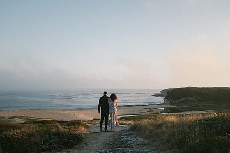 man and woman walking near body of water thumbnail