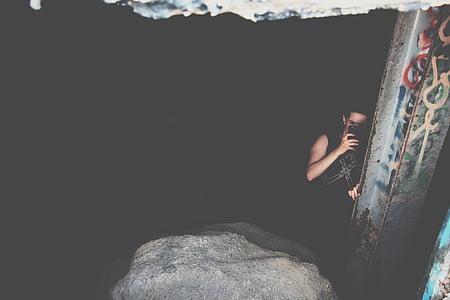 man besides blue wall inside dark building thumbnail