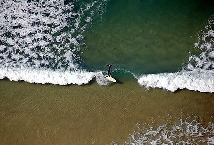 aerial photo of person surfing on beach during daytime thumbnail