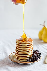 honey drizzled on stack of pancakes served on ceramic plate thumbnail