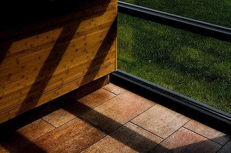 brown tiled floor beside brown wooden cabinet and black framed glass windw thumbnail
