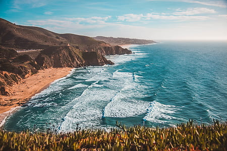 landscape photography of rock mountains and body of water during daytime thumbnail