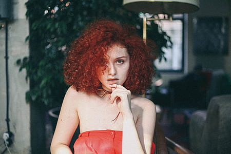 red haired woman with left hand on chin thumbnail