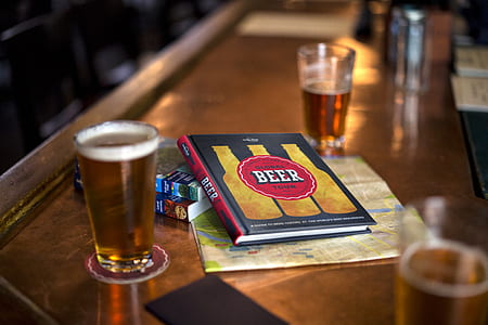 two clear glass cups beside book thumbnail