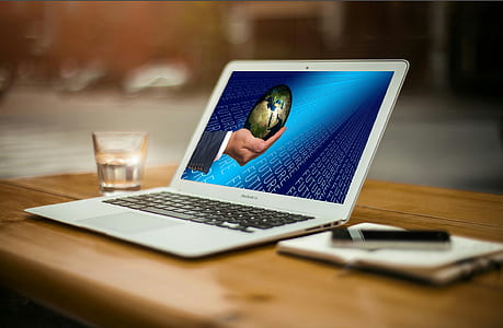 turned-on white laptop computer on brown wooden surface thumbnail
