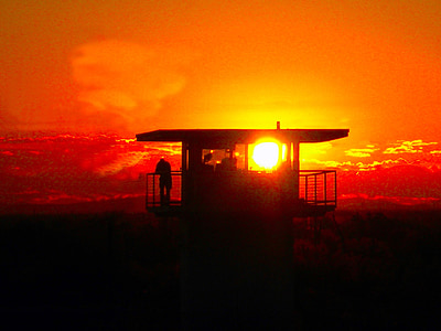 silhouette of person standing on tower house during golden hour thumbnail