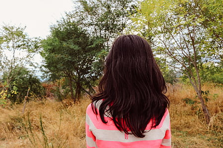 girl wearing pink shirt facing on trees thumbnail