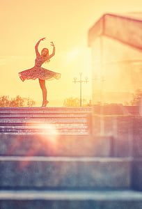 woman in black and white a-line dress dancing during golden hour thumbnail