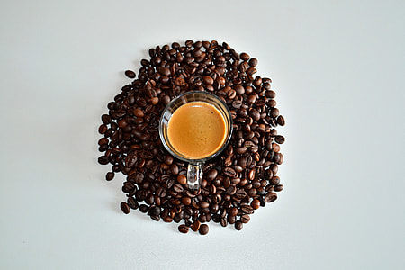 Overhead shot of coffee cup surrounded by coffee beans thumbnail