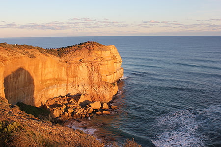 brown plateau beside sea at daytime thumbnail