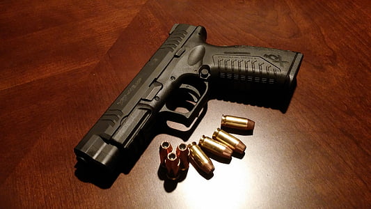 black pistol with bullets on brown surface thumbnail