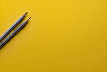 two gray pencils on yellow surface thumbnail