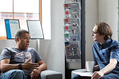two man sitting on gray fabric sofa close-up photography thumbnail