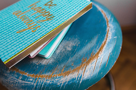 Blue notebooks and a camera on a blue wooden stool thumbnail